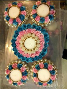 three decorated cupcakes sitting on top of a plastic container