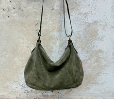 Features : - Olive green suede, - Green hand dyed leather, - Zipped bag, - Unlined, - Inside cotton zipped pocket, Size: - Height 10.63 inch, - Lenght 14.96 inch, - Shoulder belt is adjustable. Handmade olive green soft suede  hobo bag.  The bag is closed with a metallic zip.  Inside is unlined and there is a large cotton zipped pocket. There is an adjustable shoulder strap made with strong hand dyed leather and is possible add a leather amovable short handle. This medium size hobo bag is a perfect bag for every moment you can add a soft suede tassel https://www.etsy.com/it/listing/1524528378/nappina-portachiavi-in-pelle-scamosciata?click_key=f9e2bd17e98b408d7a5d75a77e936f340dffcf14%3A1524528378&click_sum=5617ff27&ref=shop_home_active_2&frs=1 Contact me for any information Suede Hobo Bag, Favorite Purse, Strong Hand, Shoulder Belt, Green Soft, Green Hand, Suede Tassel, Hobo Bags, Zipped Bag