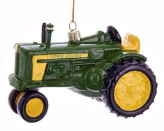 a green tractor ornament hanging from a tree