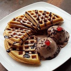 waffles and ice cream on a white plate with chocolate syrup drizzled