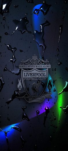 the liverpool football club logo is seen through raindrops on a dark blue background