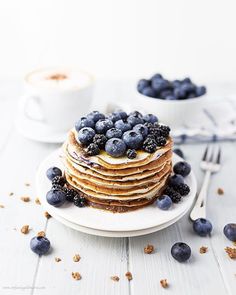 a stack of pancakes with blueberries and syrup