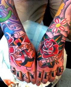 two hands that have tattoos on them and one has flowers in the middle, while the other