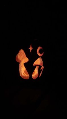 a carved pumpkin in the shape of a face with stars and crescents on it