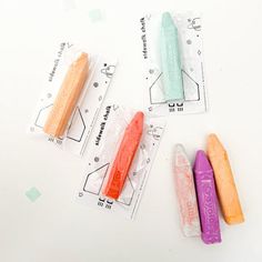 three different colored candy sticks sitting next to each other on top of a white table