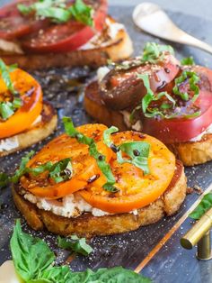 several small sandwiches with tomatoes, cheese and herbs on them are ready to be eaten