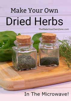 two jars filled with herbs sitting on top of a wooden cutting board