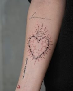 a woman with a heart tattoo on her arm