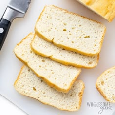 slices of white bread sitting on top of a cutting board with a knife next to it