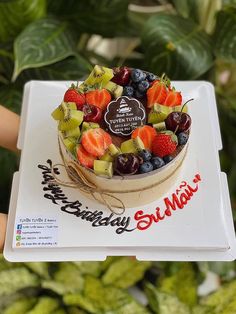 a cake with fruit on top is being held by someone