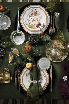 an overhead view of a table set with plates and silverware, napkins and fruit