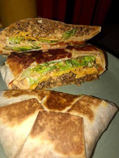 two quesadillas cut in half sitting on top of a blue tablecloth