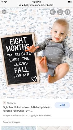 a baby laying on top of a bed next to a blackboard with the words eight months