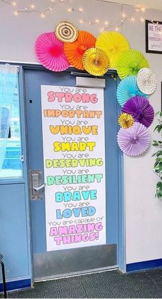 a classroom door decorated with colorful paper fans and flowers on the front entrance to an elementary school