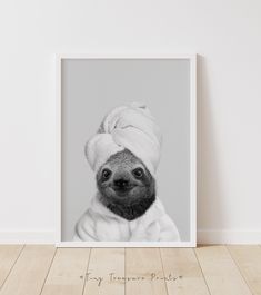 a black and white photo of a baby sloth wearing a towel on its head