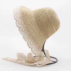 a heart - shaped object made out of crochet on a white background with a black cord