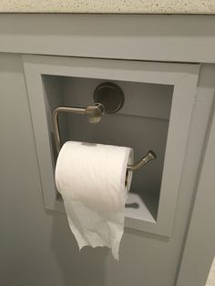 a roll of toilet paper is hanging from the wall in a bathroom cabinet with an open door