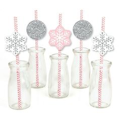 some glass vases with snowflakes on them and paper straws in them