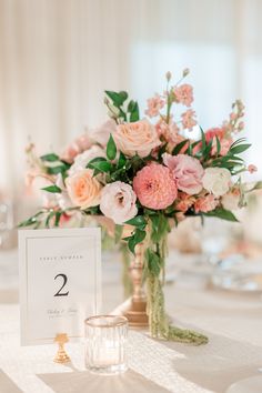 the table is set with flowers, candles and place cards for guests to sit at