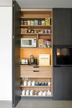 an open door leading to a kitchen with microwave, toaster oven and coffee maker