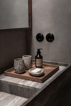 a bathroom sink with soap and lotion on it in front of two black plates