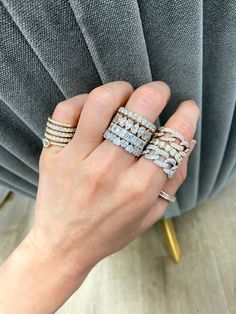 a woman's hand with three rings on top of her finger and one ring in the middle