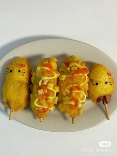 some food is on a white plate with toothpicks in the shape of cats