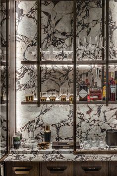 a marble bar with wine glasses and liquor bottles