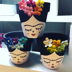 three flower pots with faces painted on them