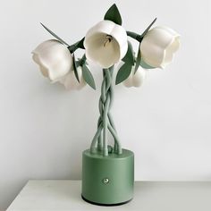 there is a green vase with white flowers in it