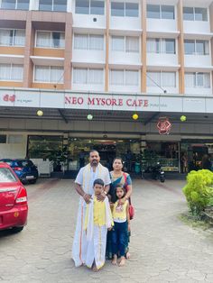 two adults and two children standing in front of a hotel