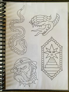 a notebook with some drawings on it and an image of a dragon, snake, and shield