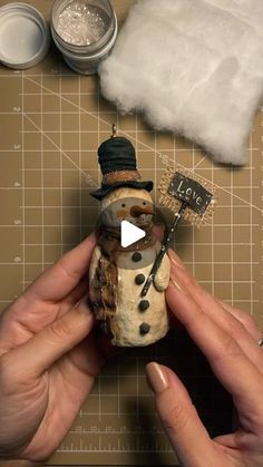 someone is making a snowman ornament out of clay