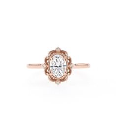 an antique style engagement ring with a round center stone in rose gold and white diamonds