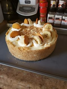 a cake sitting on top of a metal pan covered in bananas and other toppings