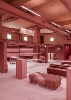 the interior of a building with pink walls and floor to ceiling lighting, benches, and stools