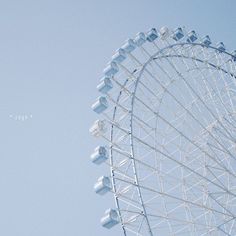 an airplane flying in the sky near a ferris wheel