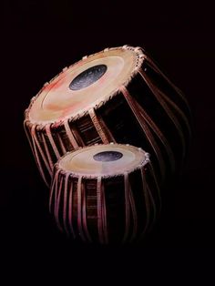 two wooden drums sitting side by side on a black background, with the top one being held up