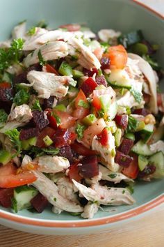 a close up of a bowl of food with meat and veggies in it