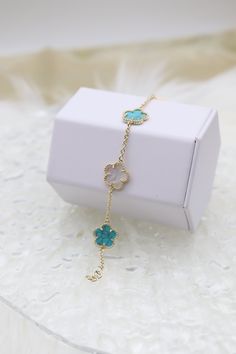 This bracelet features a pendant designed as a five-leaf flower, where one petal is crafted from lustrous mother of pearl and the other a vibrate turquoise stone. The combination of the iridescent mother of pearl and the vivid turquoise creates a stunning visual contrast, making the bracelet a standout piece for both casual and formal occasions. Length: 7” adjustable Clover: 14.4 mm Closure: Lobster Claw Material: Brass with 18K Gold Plating and Rhodium Coating Lead Free and Hypoallergenic Turquoise Jewelry With Flower Charm, Elegant Turquoise Jewelry With Mother Of Pearl, Elegant Turquoise Flower Pendant Jewelry, Elegant Turquoise Mother Of Pearl Jewelry, Turquoise Flower Charm Pendant Jewelry, Elegant Turquoise Jewelry With Flower Charm, Turquoise Flower-shaped Jewelry Gift, Turquoise Jewelry With Flower Charm As Gift, Turquoise Jewelry With Flower Charm For Gift