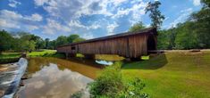 a wooden covered bridge over a small river