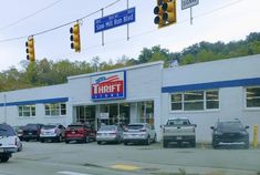 cars are parked in front of a thrift store