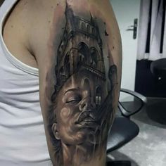 a man with a tattoo on his arm has a clock tower in the back of his head