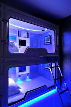 a bed room with bunk beds and blue lights in the wall next to each other