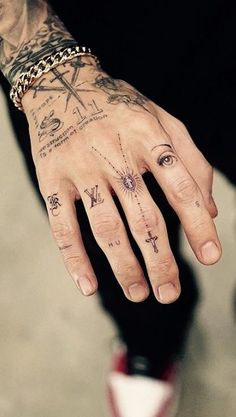 a man with tattoos on his hand and wrist is wearing a chain around his finger