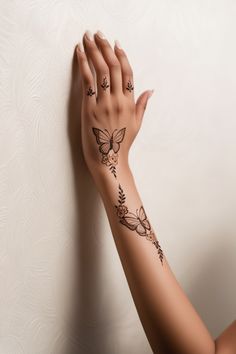 a woman's arm with tattoos on it and her hand resting against the wall