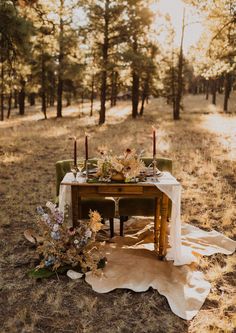 the table is set up for dinner in the woods