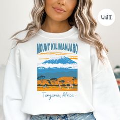 Mount Kilimanjaro Sweatshirt Gift for Mountain Climber Lover, Kilimanjaro Hiking Sweatshirt, Africa Nature Lover Shirt, Vintage Kilimanjaro . Orders are processed within 24 hours and shipped out within 2 to 5 business days.  What you receive: Gildan Brand Adult Unisex Organic Cotton & Fleece Sweatshirt Color Choices: White Light Blue Navy Maroon Forest Green Sizes: Unisex adult sizing run true to size. If you prefer an oversized shirt, order one size larger than you usually wear. Please use the size chart as a guide.  Care Instructions: Machine wash: warm (max 40C or 105F); non-chlorine: bleach as needed; Tumble dry: medium heat; Do not iron; Do not DryClean. 100% SATISFACTION GUARANTEED We strive to provide the best products and the best service. If you are unhappy with your experience, p White Crew Neck Sweatshirt For Outdoor Activities, White Graphic Print Sweatshirt For Outdoor Activities, White Relaxed Fit Sweatshirt For Outdoor Activities, White Graphic Print Sweatshirt For Outdoor, White Long Sleeve Adventure T-shirt, White Long Sleeve T-shirt For Adventure, White Long Sleeve Sweatshirt For Adventure, White Long Sleeve Hiking Tops, White Long Sleeve Tops For Hiking