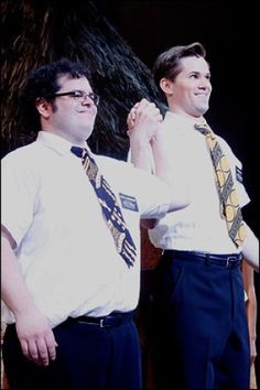 two men standing next to each other wearing ties