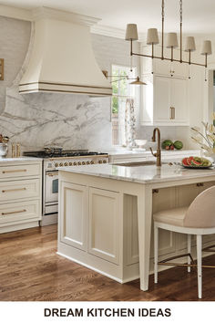 a kitchen with white cabinets and an island in the middle, surrounded by hanging lights